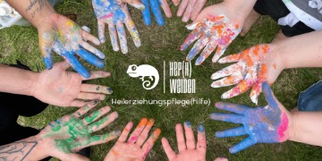 Mehrere mit bunten Farben besprenkelte Hände bilden einen Kreis um das Logo der Heilerziehungspflegeschule Weiden