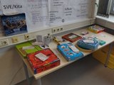 Spieleauswahl Das Bild zeigt einen Tisch auf dem viele verschiedene Brett- und Kartenspiele liegen.