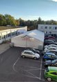 Das Bild zeigt einen Überblick über den Parkplatz der Fachschulen, auf dem ein Festzelt aufgebaut wurde. Daneben stehen Autos.