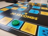 Spiele kennenlernen Das Bild zeigt ein schwarz, blau und gelbes Spielbrett mit Spielfiguren darauf.