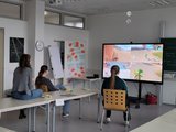 Konsolenspiel ausprobieren Das Bild zeigt drei Schülerinnen das Heilerziehungspflegerischen Einführungsjahr beim Spielen eines Konsolenspiels vor einem digitalen Whiteboard.