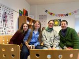 Das Bild zeigt vier Schülerinnen, die nebeneinander sitzen und lachen.