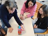 Jenga spielen Das Foto zeigt zwei Lehrerinnen und eine Schülerin beim Jenga-Spielen