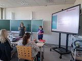 Vortrag der OBA Zwei Referentinnen der offenen Behindertenarbeit Weiden stehen vor der Tafel und erzählen von ihrer Arbeit.