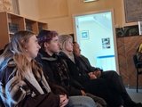 Die Schüler*innen sitzen in der Synagoge und hören dem Vortragenden zu.