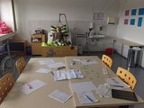 Escaperoom Das Bild zeigt einen Tisch im Pflegeraum, auf dem Zettel zur Lösung von Escaperoom-Rätseln liegen.