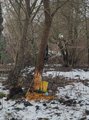 Das Bild zeigt eine Land-Art-Skulptur aus Stöcken, Blättern und im Wald gefundenem Müll im Schnee. Sie soll die Vermüllung des Waldes zeigen
