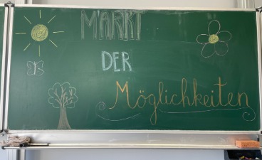 Das Bild zeigt die Tafel mit der Aufschrift "Markt der Möglichkeiten"