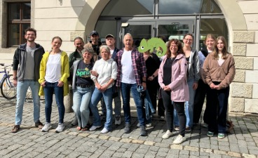 Die Gruppe der Heileziehungspflegehelfer:innen und die des Heilerziehungspflegerischen Einführungsjahrs posieren zusammen vor der Regionalbibliothek Weiden zum Gruppenfoto