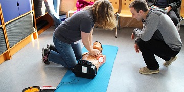 Erste-Hilfe Präsentation mit Defibrillator Schülerin bei Präsentation mit Defibrillator
